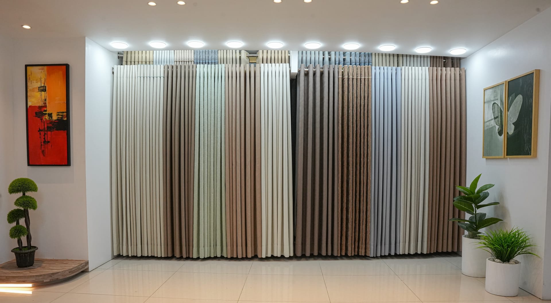 Wall of textured curtain fabrics in neutral tones at the Hello Sun studio